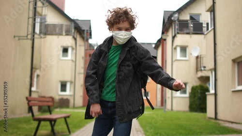 Wallpaper Mural Close portrait of a curly masked schoolboy with a backpack comes back from school and dances. Crazy dancing, quarantine ending, post-quarantine life Torontodigital.ca