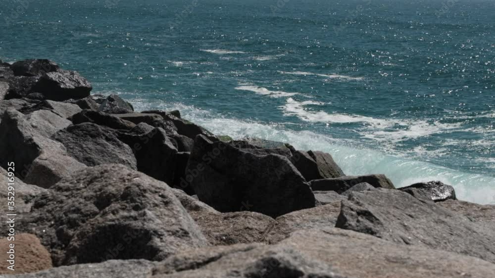 Waves splashing against rocks on sea wall in Povoa de Varzim, Portugal in slow motion Waves splashing against rocks on sea wall in Povoa de Varzim, Portugal in slow motion