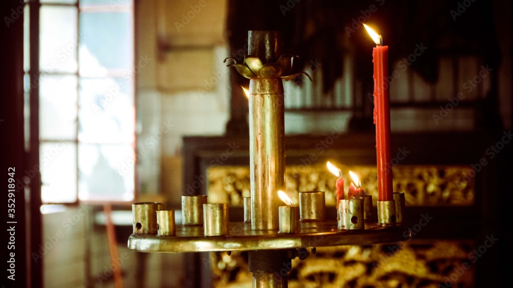 Burning red candles on the gold holder