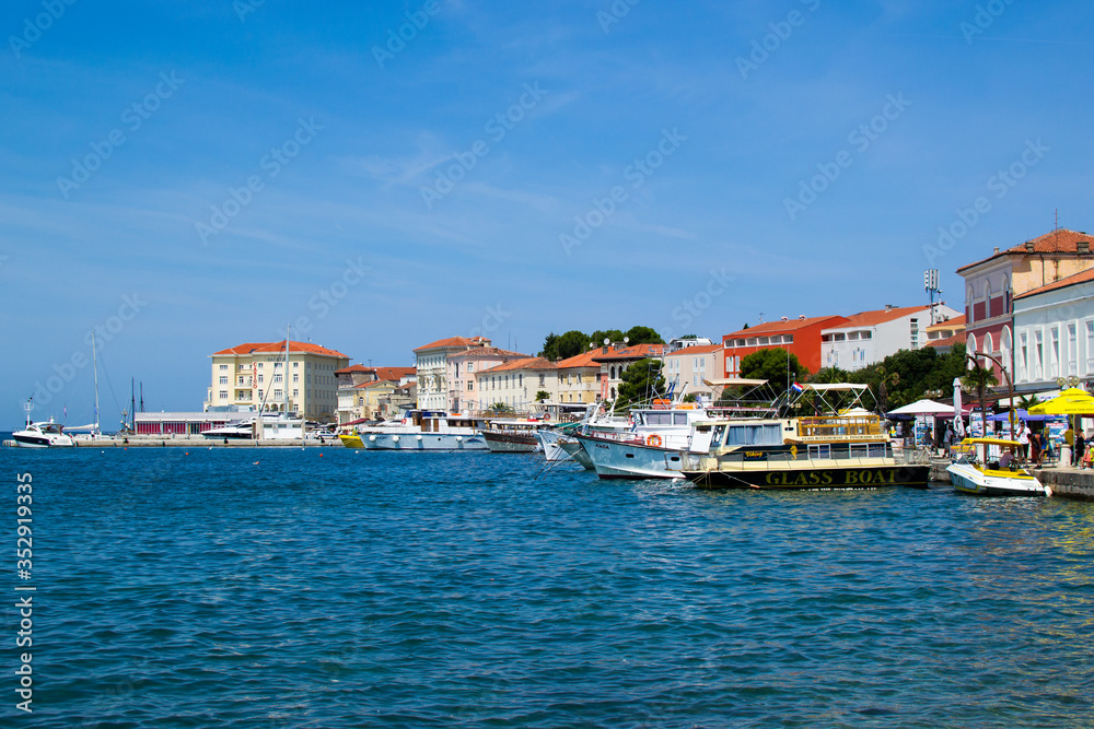 Porec (Parenzo), Croatia; 7/19/19: View of the typical croatian houses in the coastline of the old town of Porec (also called Parenzo), Croatia, with boats anchored on the port in Adriatic Sea
