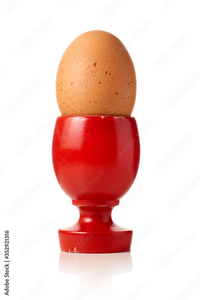 soft-boiled egg served on red wooden egg cup isolated in total white background soft-boiled egg served on red wooden egg cup isolated in total white background