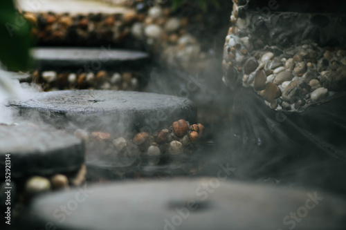 Defocused and blurred image for background. Hot Springs, Boiling and steaming water in geyser vent. Steaming geothermal hot water, Large stones arranged, Boiling water splash. closeup, vintage style.