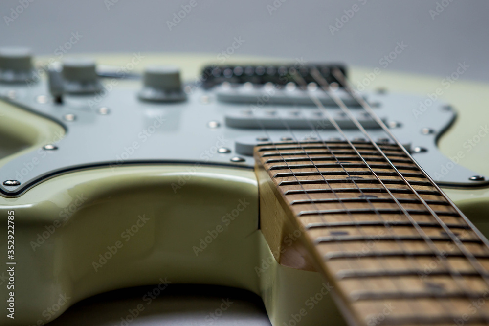 Fototapeta premium White electric guitar on a white background. In the photo, the neck and guitar deck