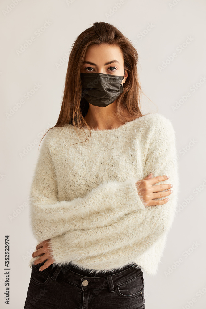 Young woman wearing medical face mask, studio portrait Young woman wearing medical face mask, studio portrait