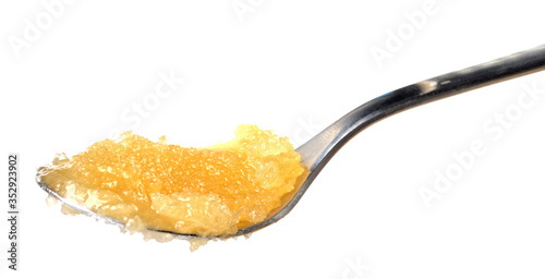 Teaspoon of honey isolated on white background.