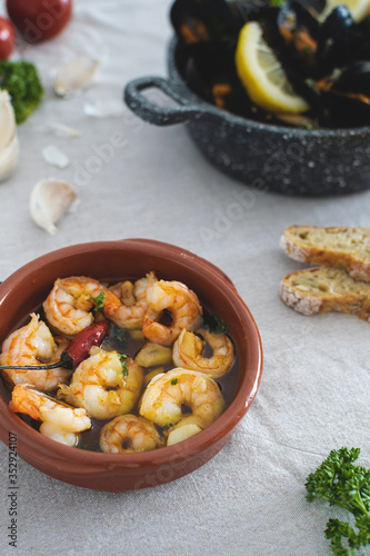 Selective focus on traditional spanish garlic prawns fried in spicy olive oil with parsley