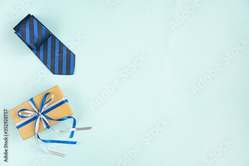  Happy Fathers Day. Gift box and festive decoration on light blue table. Top view, flat lay, copy space