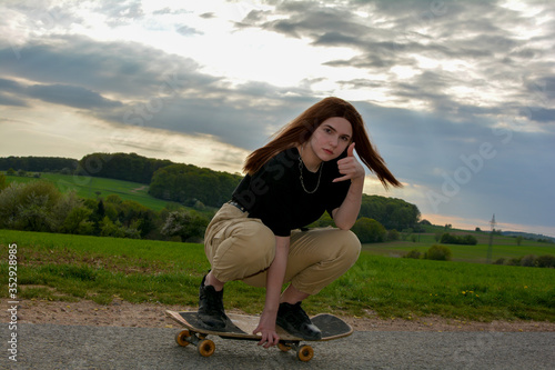 Young girl skates on a road in nature
