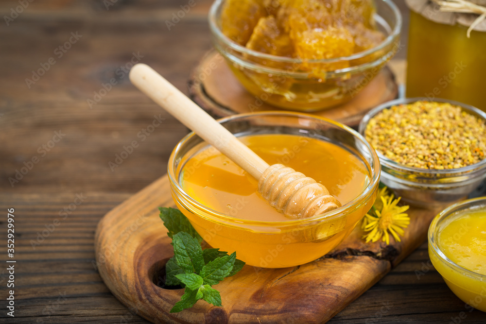 Fresh honey in the bowl, with honeycomb and bee pollen Fresh honey in the bowl, with honeycomb and bee pollen