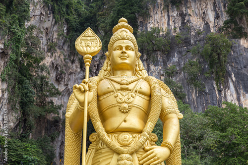 Photography Close view on the huge golden statue of Hindu god Murugan at the entrance of Bat