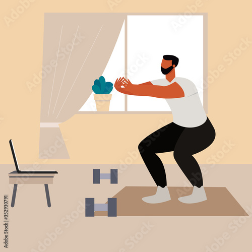 Man watching online workout and doing sport at home. Home workout during quarantine. 