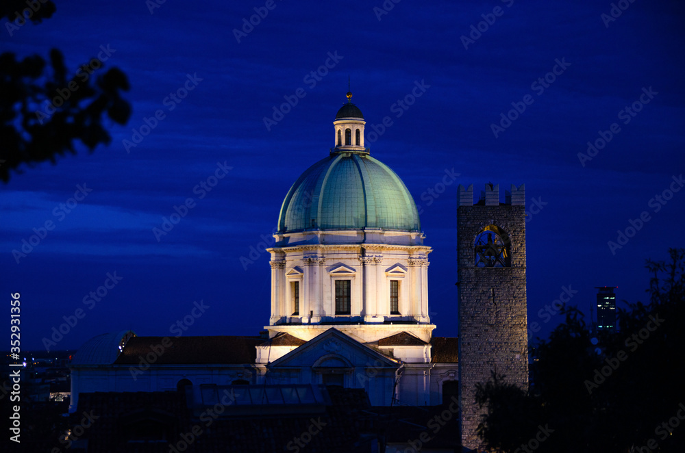 Dome of Santa Maria Assunta New Cathedral, Duomo Nuovo Roman Catholic church and Tower of Palazzo del Broletto palace, night evening view, Brescia city historical centre, Lombardy, Northern Italy