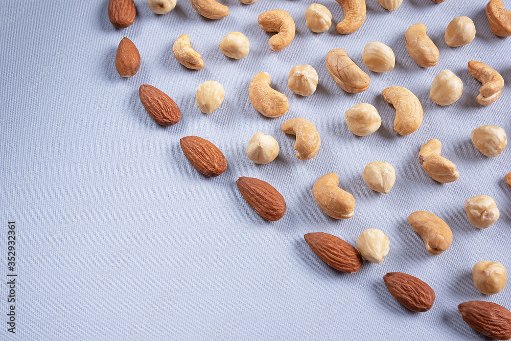 Walnut background. Healthy fats. Different nuts on a gray surface. Walnut background. Healthy fats. Different nuts on a gray surface.