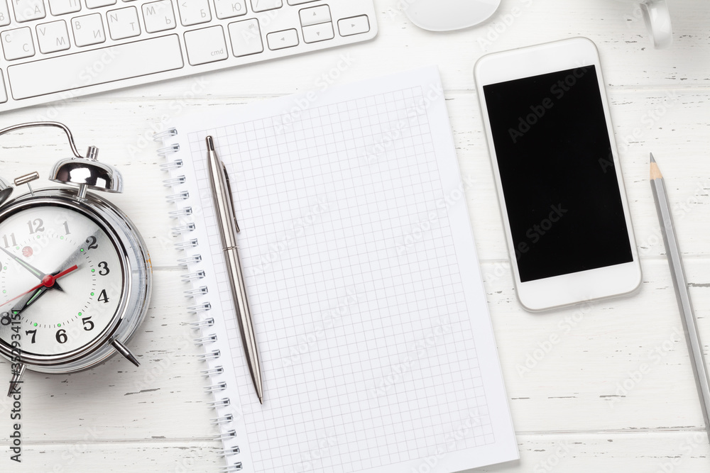 Workplace with smartphone, supplies and alarm clock Workplace with smartphone, supplies and alarm clock