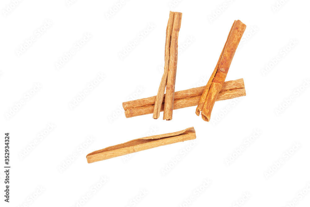 Three pieces of cinnamon lie on a white background, close-up. Three pieces of cinnamon lie on a white background, close-up.