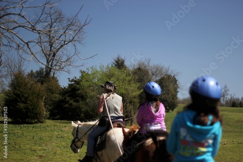 Horse riding guide is leading group of children