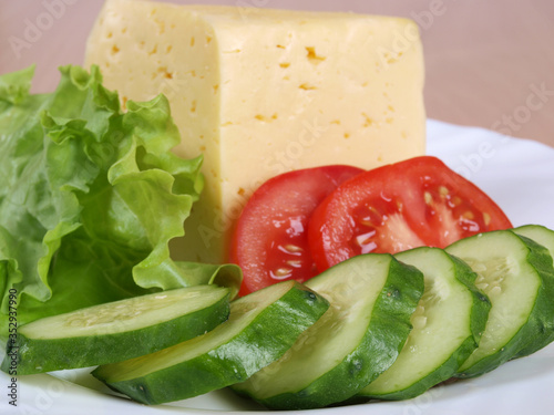 Green salad and cheese on a porcelain plate