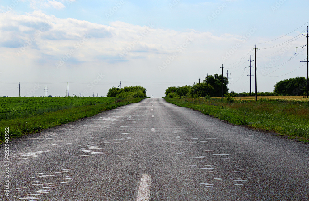 An empty asphalt road through the rural landscape.