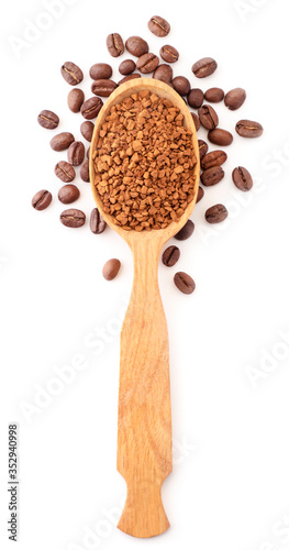Instant coffee in a wooden spoon, coffee grains around isolated. The view from top