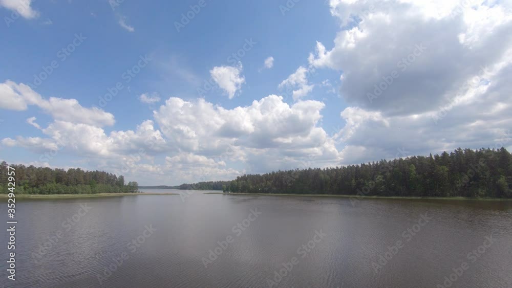 Aerial: Beautiful Nature Scenery Of Bright Cloudy Sky And Lush Trees By The Lake - wide shot Aerial: Beautiful Nature Scenery Of Bright Cloudy Sky And Lush Trees By The Lake - wide shot