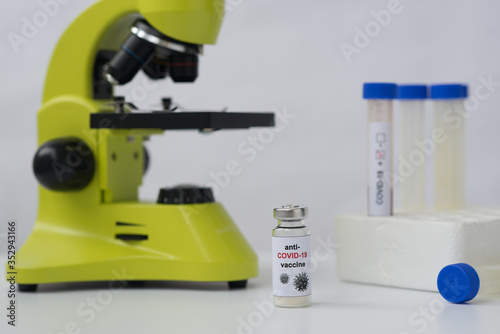 Anti-COVID-19 vaccine, microscope and tubes with blood positive to coronavirus. Landscape orientation. White background. 
