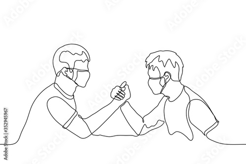 Two men in medical protective masks are engaged in arm wrestling. Arm wrestling, wrestling, a dispute between two friends, the concept of conflict of interests. Can be used for animation.