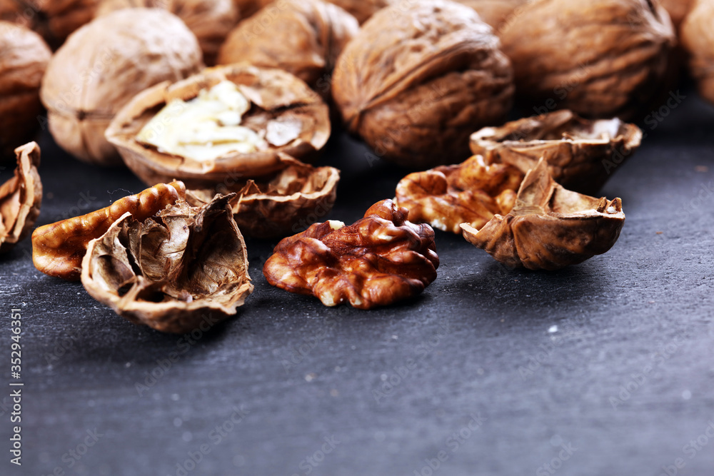 Walnut kernels and group of whole walnuts on rustic old table Walnut kernels and group of whole walnuts on rustic old table
