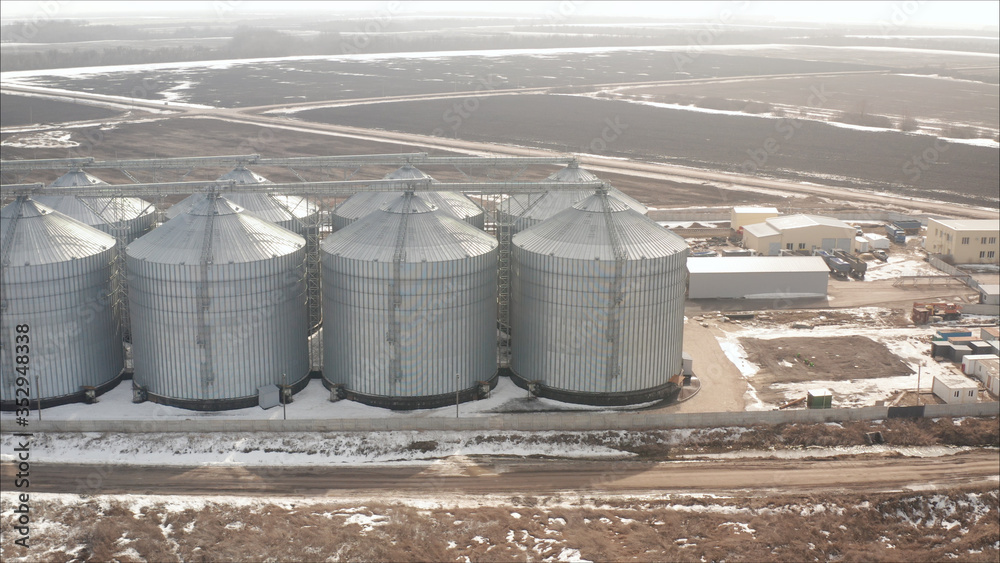 Aerial view of drone on a large granary in a field on a background of a sunset. A new, built-in industrial grain elevator taken from a quadrocopter. Aerial view of drone on a large granary in a field on a background of a sunset. A new, built-in industrial grain elevator taken from a quadrocopter.