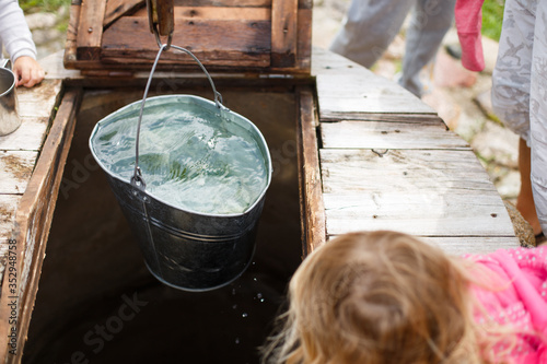 Blue bucked inside water well. A water well with an old iron bucket photo