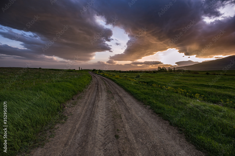 road in field at the sunset