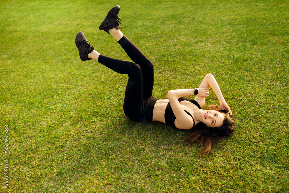 Happy sporty woman resting after training on the stadium Happy sporty woman resting after training on the stadium