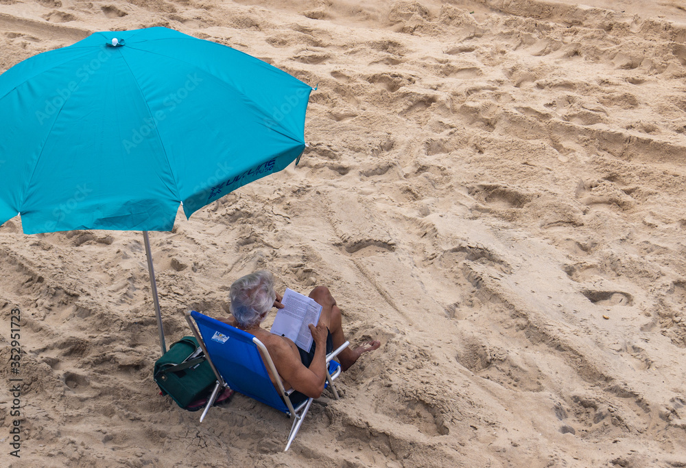 Man reading at beach chair close up - (Barra - Salvador - Brazil - Dec2018) Man reading at beach chair close up - (Barra - Salvador - Brazil - Dec2018)