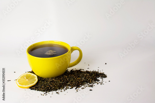 yellow cup with delicious tea and lemon (lime)
