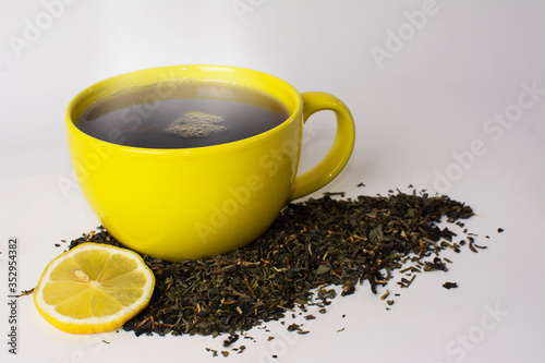 yellow cup with delicious tea and lemon (lime)