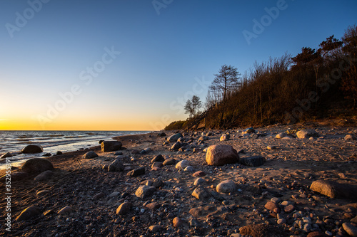 Beautiful romantic sunset at empty Karkle beach with many stones, Klaipeda/ Lithuania