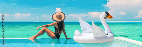 Canvas Print Luxury swimming pool vacation travel lady sun tanning relaxing on infinity ocean waterfront resort with floating white swan inflatable toy float banner panoramic summer background