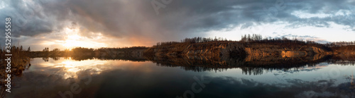 Mirror image in the lake of steep banks at sunset. Vsevolozhsk. Leningrad region.