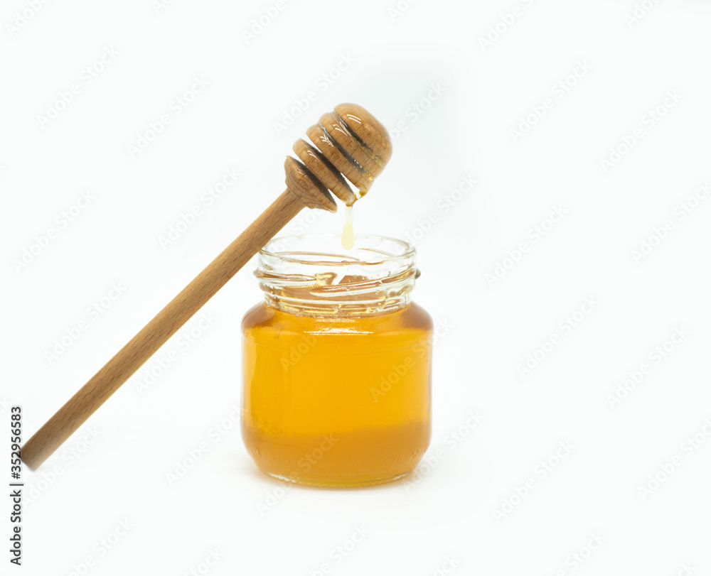 jar of honey with a spoon of honey on a white background jar of honey with a spoon of honey on a white background