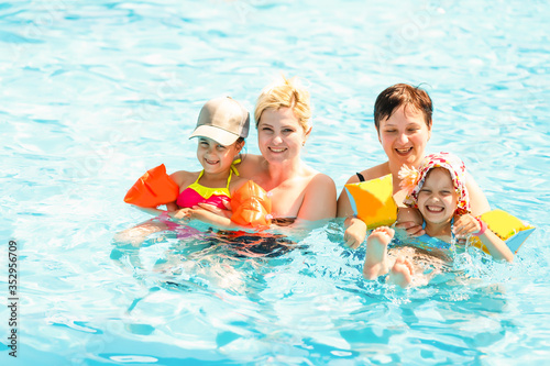 two women and their children in the pool