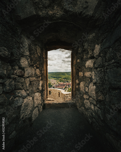 Dark stone window of the castle Hohenurach with view to the town Bad Urach