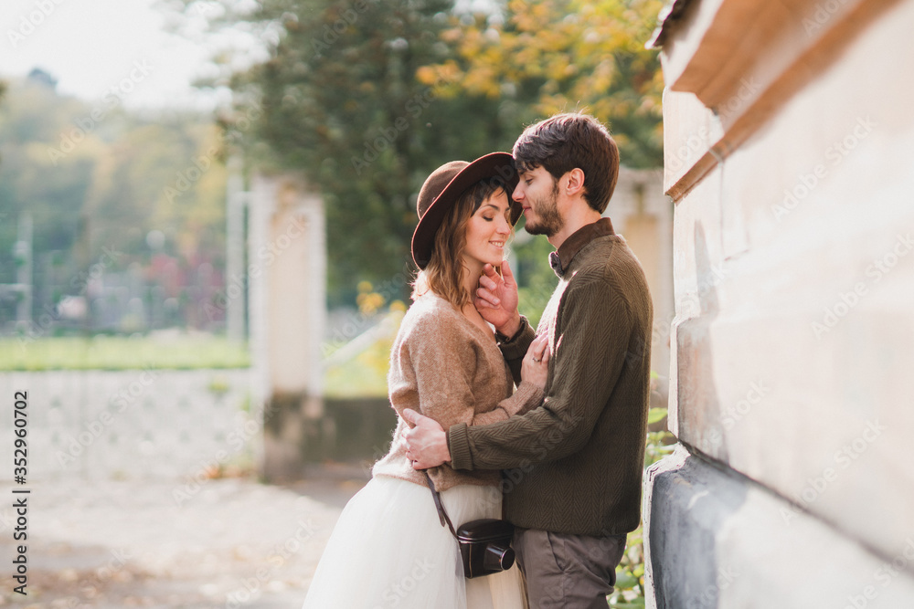 Romantic and happy caucasian couple in casual wedding clothes walking and hugging at the city streets. Love, relationships, romance, happiness, urban concept. Man and woman celebrate their marriage.