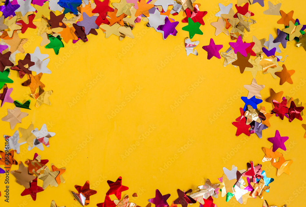 Multi-colored confetti on a yellow background with space for text.