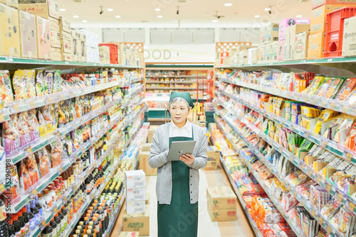 Senior woman checking restock in supermarket photo