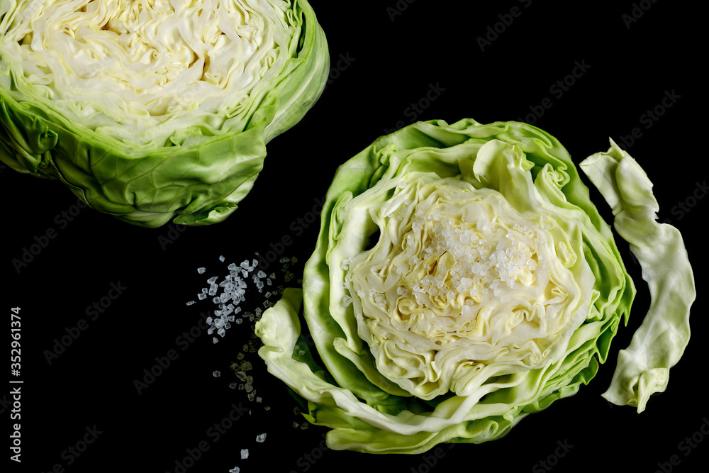 white cabbage slice and coarse sea salt on a black background white cabbage slice and coarse sea salt on a black background
