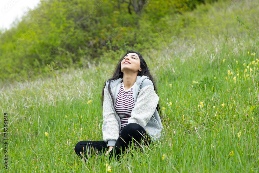 happy woman sitting in green grass happy woman sitting in green grass