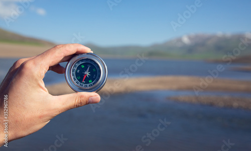 man hand compass in lake
