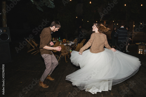 Romantic and happy caucasian couple in casual wedding clothes dancing at the night party. Love, relationships, romance, happiness, urban concept. Man and woman celebrate their marriage.