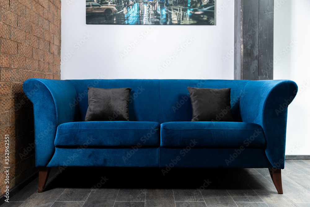 Blue Sofa in the room with white walls.
