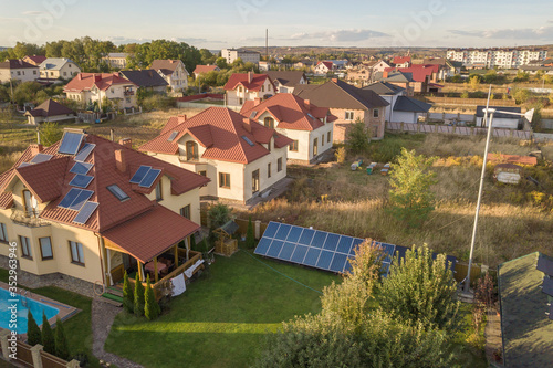Wallpaper Mural Aerial view of a residential private house with solar panels on roof and wind generator turbine. Torontodigital.ca