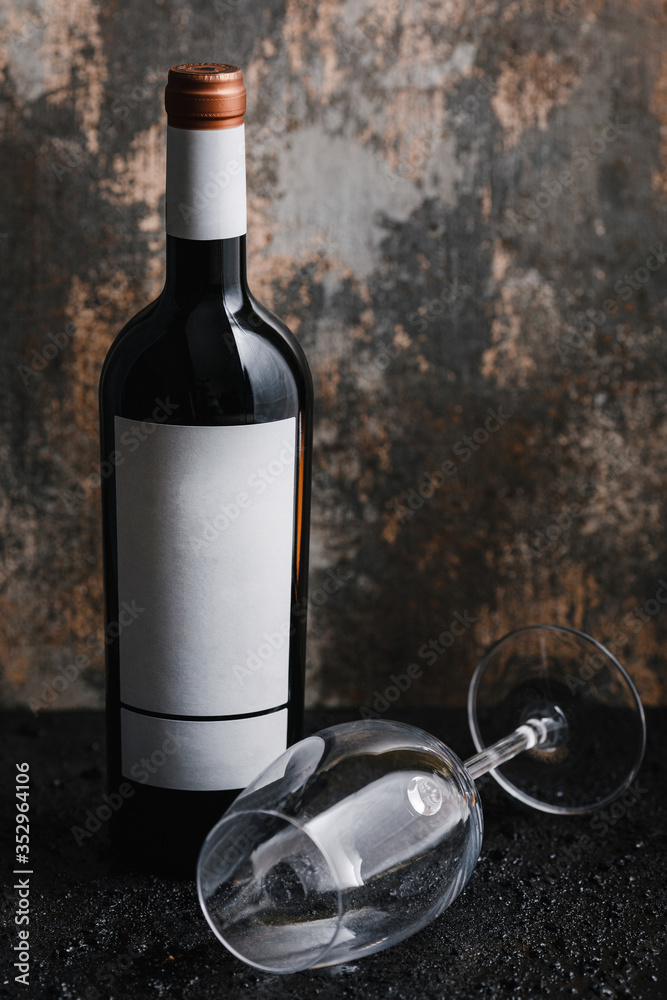 Photo of a bottle of wine and glass on black isolated background